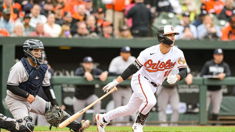 Apr 7, 2023; Baltimore, Maryland, USA; Baltimore Orioles second baseman Adam Frazier (12) hits a  second inning rbi single against the New York Yankees at Oriole Park at Camden Yards. Mandatory Credit: Tommy Gilligan-USA TODAY Sports