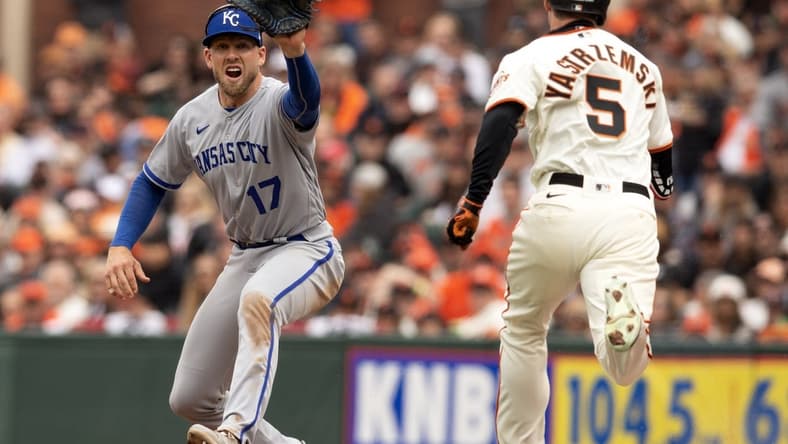 Apr 7, 2023; San Francisco, California, USA; Kansas City Royals first baseman Hunter Dozier (17) takes the relay in time to retire San Francisco Giants center fielder Mike Yastrzemski (5) on a bunt attempt during the sixth inning at Oracle Park. Mandatory Credit: D. Ross Cameron-USA TODAY Sports
