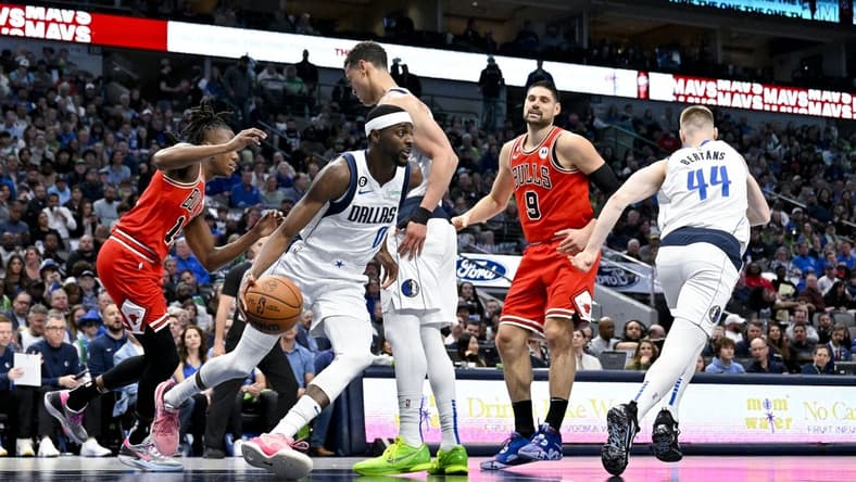 Apr 7, 2023; Dallas, Texas, USA; Dallas Mavericks forward Justin Holiday (0) grabs a rebound against the Chicago Bulls during the first quarter at the American Airlines Center. Mandatory Credit: Jerome Miron-USA TODAY Sports