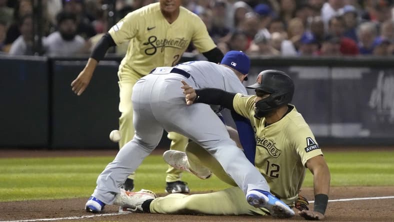 Apr 7, 2023; Phoenix, Arizona, USA; Arizona Diamondbacks left fielder Lourdes Gurriel Jr. (12) slides into Los Angeles Dodgers third baseman Max Muncy (13) safely in the third inning at Chase Field. Mandatory Credit: Rick Scuteri-USA TODAY Sports