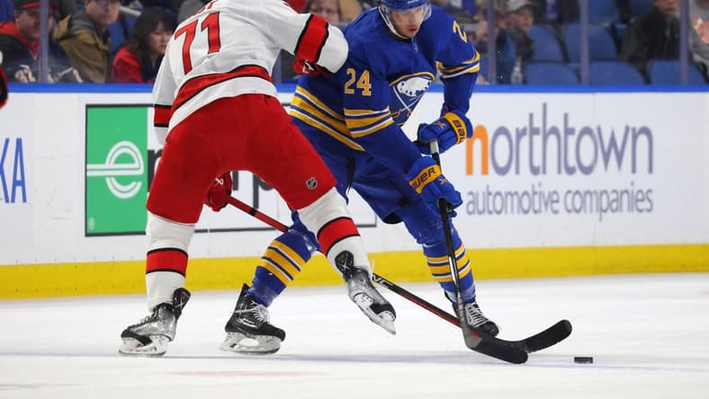 Apr 8, 2023; Buffalo, New York, USA; Carolina Hurricanes right wing Jesper Fast (71) and Buffalo Sabres center Dylan Cozens (24) go after a loose puck during the first period at KeyBank Center. Mandatory Credit: Timothy T. Ludwig-USA TODAY Sports