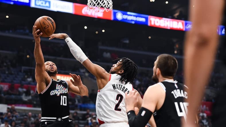 Apr 8, 2023; Los Angeles, California, USA; LA Clippers guard Eric Gordon (10) grabs a rebound against Portland Trail Blazers forward Trendon Watford (2) during the first quarter at Crypto.com Arena. Mandatory Credit: Jonathan Hui-USA TODAY Sports