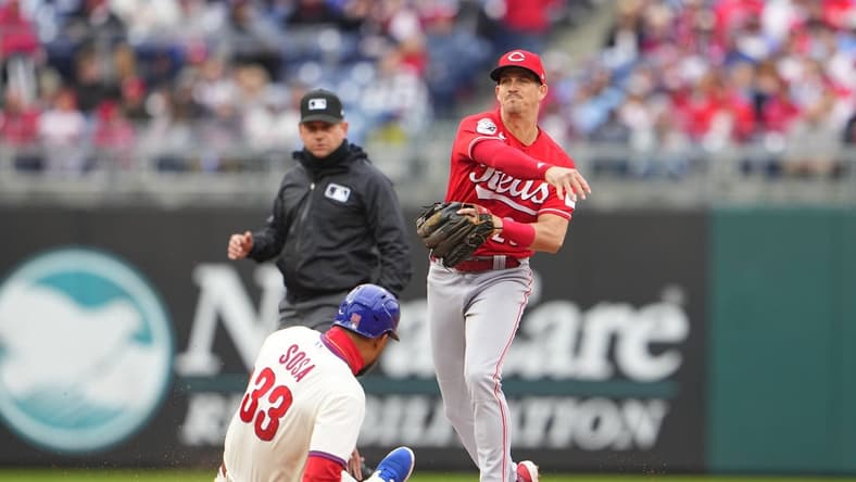 Apr 8, 2023; Philadelphia, Pennsylvania, USA; Cincinnati Reds shortstop Kevin Newman (28) turns a double play over Philadelphia Phillies third baseman Edmundo Sosa (33) during the fifth inning at Citizens Bank Park. Mandatory Credit: Gregory Fisher-USA TODAY Sports