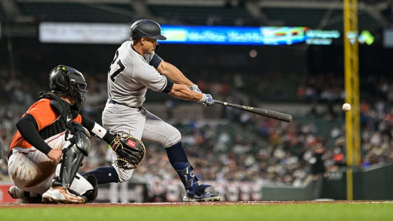 Apr 8, 2023; Baltimore, Maryland, USA;  New York Yankees right fielder Giancarlo Stanton (27) hits a third inning single against the Baltimore Orioles at Oriole Park at Camden Yards. Mandatory Credit: Tommy Gilligan-USA TODAY Sports