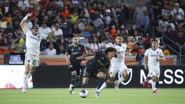 Apr 8, 2023; Houston, Texas, USA; Houston Dynamo FC midfielder Adalberto Carrasquilla (20) and LA Galaxy midfielder Marco Delgado (8) battle for the ball during the first half at Shell Energy Stadium. Mandatory Credit: Troy Taormina-USA TODAY Sports