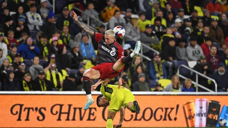 Apr 8, 2023; Nashville, Tennessee, USA; Toronto FC forward Federico Bernardeschi (10) and Nashville SC defender Daniel Lovitz (2) battle for a ball during the second half at Geodis Park. Mandatory Credit: Christopher Hanewinckel-USA TODAY Sports
