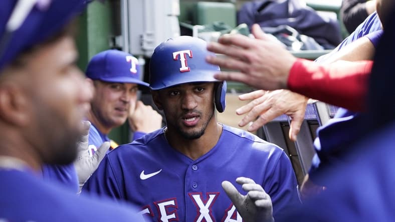 Apr 9, 2023; Chicago, Illinois, USA; Texas Rangers center fielder Bubba Thompson (8) is greeted in the dugout after scoring against the Chicago Cubs during the sixth inning at Wrigley Field. Mandatory Credit: David Banks-USA TODAY Sports