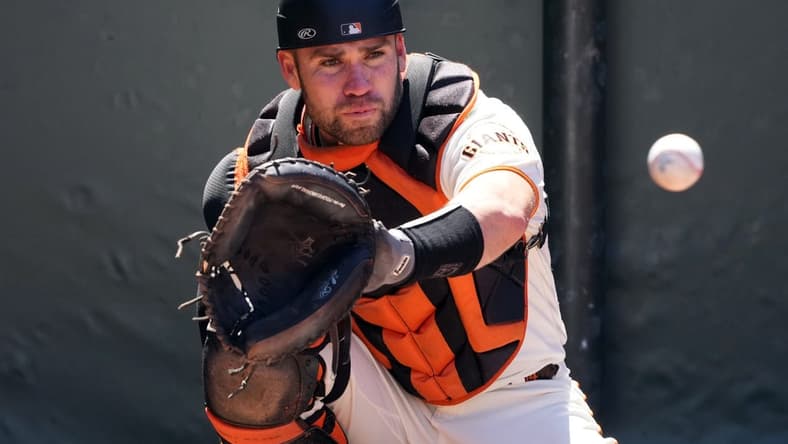 Apr 9, 2023; San Francisco, California, USA; San Francisco Giants catcher Austin Wynns (14) warms up before the game against the Kansas City Royals at Oracle Park. Mandatory Credit: Darren Yamashita-USA TODAY Sports