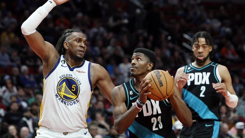 Apr 9, 2023; Portland, Oregon, USA; Portland Trail Blazers forward Jeenathan Williams (23) attempts to score as Golden State Warriors forward Kevon Looney (5) defends during the second half at Moda Center. Mandatory Credit: Soobum Im-USA TODAY Sports