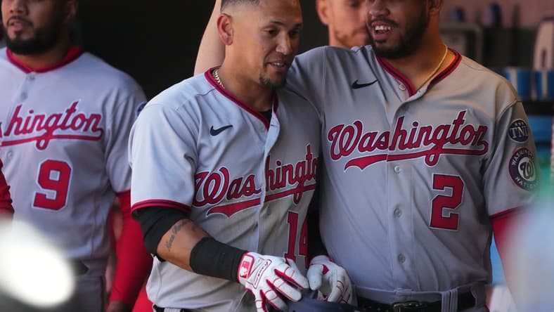 Apr 9, 2023; Denver, Colorado, USA; Washington Nationals second baseman Ildemaro Vargas (14) celebrates walking in a run with infielder Luis Garcia (2) in the sixth inning against the Colorado Rockies at Coors Field. Mandatory Credit: Ron Chenoy-USA TODAY Sports
