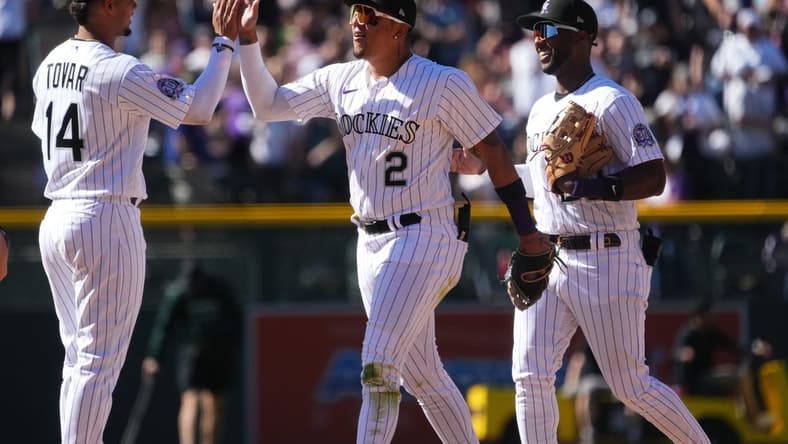 Apr 9, 2023; Denver, Colorado, USA; Colorado Rockies shortstop Ezequiel Tovar (14) and center fielder Yonathan Daza (2) and left fielder Jurickson Profar (29) celebrate defeating the Washington Nationals at Coors Field. Mandatory Credit: Ron Chenoy-USA TODAY Sports