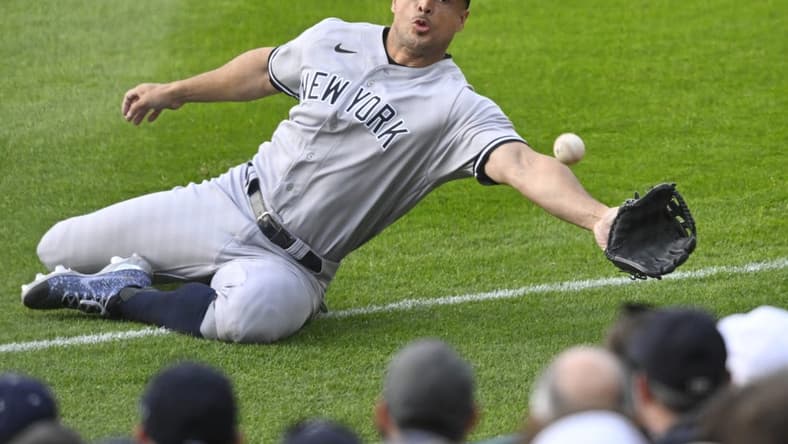 Apr 10, 2023; Cleveland, Ohio, USA; New York Yankees right fielder Giancarlo Stanton (27) reaches for a ball that landed foul in the second inning against the Cleveland Guardians at Progressive Field. Mandatory Credit: David Richard-USA TODAY Sports