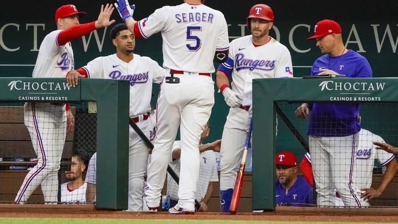 Apr 10, 2023; Arlington, Texas, USA; Texas Rangers shortstop Corey Seager (5) is greeted at the dugout after hitting a solo home run during the first inning against the Kansas City Royals at Globe Life Field. Mandatory Credit: Raymond Carlin III-USA TODAY Sports