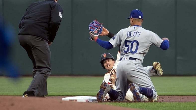 Apr 10, 2023; San Francisco, California, USA; Los Angeles Dodgers second baseman Mookie Betts (50) tags out San Francisco Giants right fielder Mike Yastrzemski (5) as he is caught attempting to steal second base during the first inning at Oracle Park. Umpire is Alex Tosi. Mandatory Credit: D. Ross Cameron-USA TODAY Sports