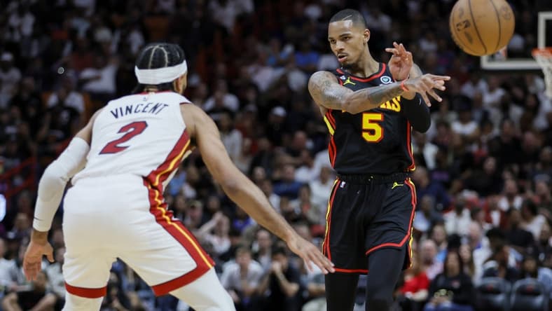Apr 11, 2023; Miami, Florida, USA; Atlanta Hawks guard Dejounte Murray (5) passes the ball as Miami Heat guard Gabe Vincent (2) defends during the second quarter at Kaseya Center. Mandatory Credit: Sam Navarro-USA TODAY Sports