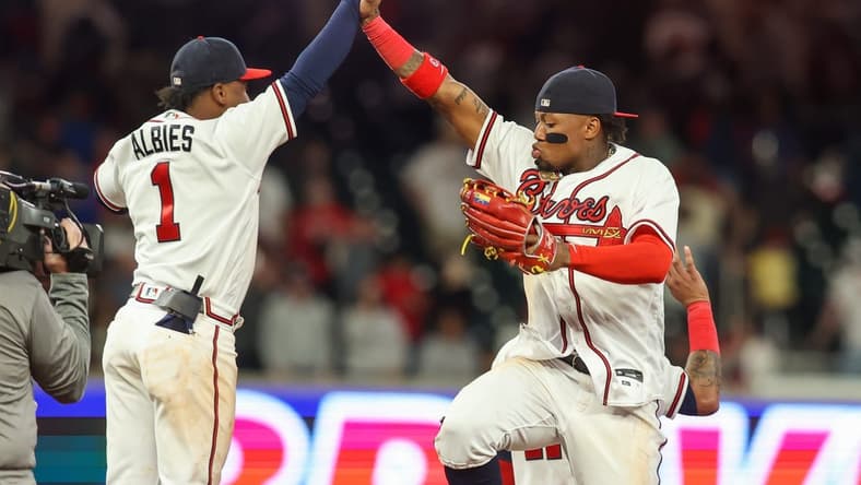 Apr 11, 2023; Atlanta, Georgia, USA; Atlanta Braves second baseman Ozzie Albies (1) and right fielder Ronald Acuna Jr. (13) celebrate a victory against the Cincinnati Reds at Truist Park. Mandatory Credit: Brett Davis-USA TODAY Sports