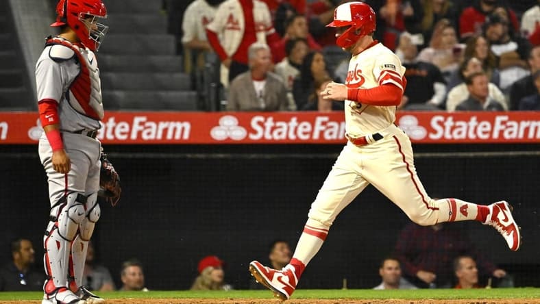 Apr 11, 2023; Anaheim, California, USA;  Washington Nationals catcher Keibert Ruiz (20) looks on as Los Angeles Angels left fielder Taylor Ward (3) crosses the plate to score a run on a sacrifice fly by third baseman Anthony Rendon (6) in the fourth inning at Angel Stadium. Mandatory Credit: Jayne Kamin-Oncea-USA TODAY Sports