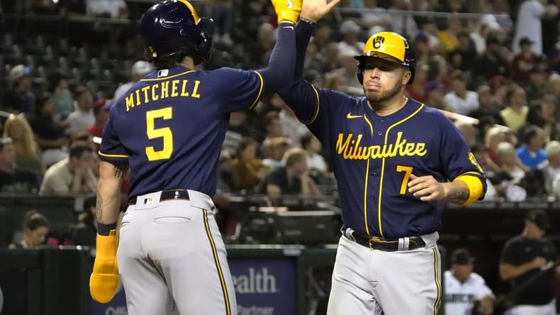 Apr 11, 2023; Phoenix, Arizona, USA; Milwaukee Brewers catcher Victor Caratini (7) celebrates with center fielder Garrett Mitchell (5) after scoring against the Arizona Diamondbacks in the seventh inning at Chase Field. Mandatory Credit: Rick Scuteri-USA TODAY Sports