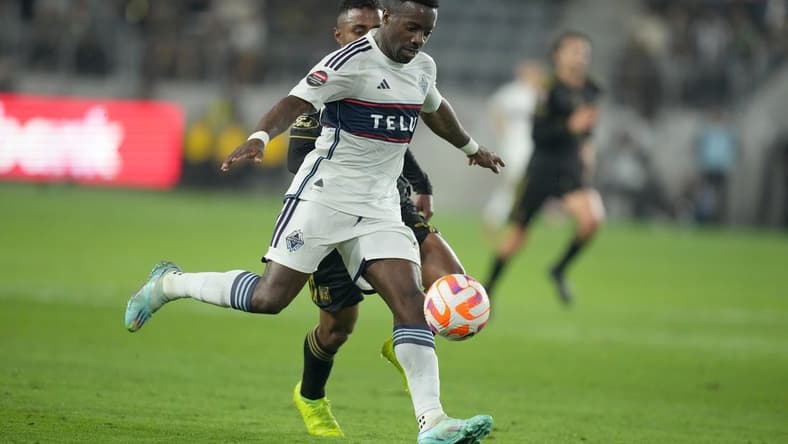 Apr 11, 2023; Los Angeles, CA, USA; Vancouver Whitecaps forward Cristian Dajome (11) and LAFC defender Diego Palacios (12) battle for the ball in the first half at BMO Stadium. Mandatory Credit: Kirby Lee-USA TODAY Sports
