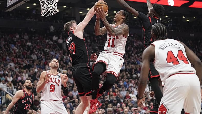 Apr 12, 2023; Toronto, Ontario, CAN; Toronto Raptors center Jakob Poeltl (19) and forward Chris Boucher (25) block a shot attempt by Chicago Bulls forward DeMar DeRozan (11) during the NBA Play-In game at Scotiabank Arena. Mandatory Credit: John E. Sokolowski-USA TODAY Sports