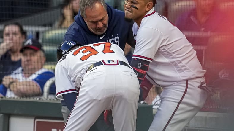 Apr 12, 2023; Cumberland, Georgia, USA; Atlanta Braves shortstop Orlando Arcia (11) is checked after being hit by a pitch against the Cincinnati Reds during the second inning at Truist Park. Mandatory Credit: Dale Zanine-USA TODAY Sports