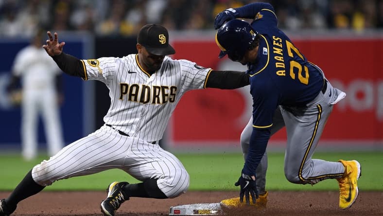 Apr 13, 2023; San Diego, California, USA; Milwaukee Brewers shortstop Willy Adames (27) steals second base ahead of the tag by San Diego Padres shortstop Xander Bogaerts (left) during the third inning at Petco Park. Mandatory Credit: Orlando Ramirez-USA TODAY Sports