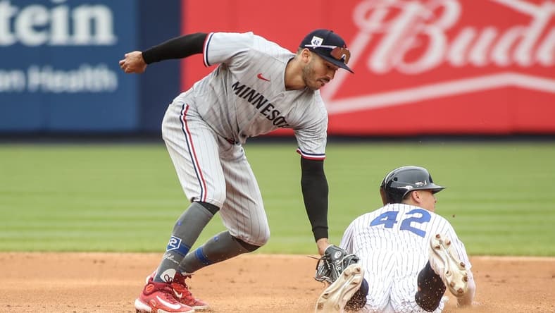 Apr 15, 2023; Bronx, New York, USA;  New York Yankees shortstop Anthony Volpe beats the tag of Minnesota Twins shortstop Carlos Correa for a stolen base in the fifth inning at Yankee Stadium. Mandatory Credit: Wendell Cruz-USA TODAY Sports