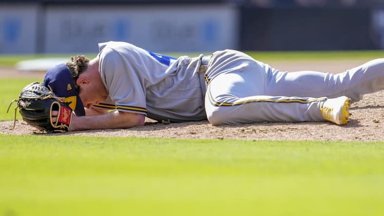 Apr 15, 2023; San Diego, California, USA;  Milwaukee Brewers relief pitcher Gus Varland lies on the ground after being hit by a line out by San Diego Padres third baseman Manny Machado (not pictured) during the eighth inningat Petco Park. Mandatory Credit: Ray Acevedo-USA TODAY Sports