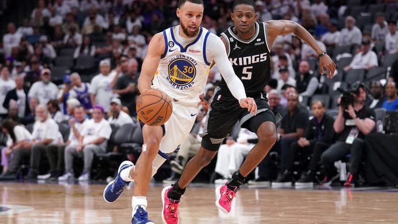 Apr 15, 2023; Sacramento, California, USA; Golden State Warriors guard Stephen Curry (30) dribbles past Sacramento Kings guard De'Aaron Fox (5) in the third quarter during game one of the 2023 NBA playoffs at the Golden 1 Center. Mandatory Credit: Cary Edmondson-USA TODAY Sports