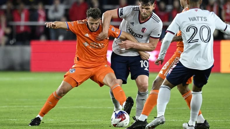 Apr 15, 2023; St. Louis, Missouri, USA; FC Cincinnati defender Santiago Arias (13) and St. Louis City midfielder Eduard Lowen (10) battle for the ball during the second half at CITYPARK. Mandatory Credit: Scott Rovak-USA TODAY Sports