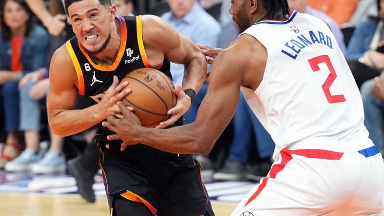 Apr 16, 2023; Phoenix, Arizona, USA; Phoenix Suns guard Devin Booker (1) drives against LA Clippers forward Kawhi Leonard (2) during the first half of game one of the 2023 NBA playoffs at Footprint Center. Mandatory Credit: Joe Camporeale-USA TODAY Sports