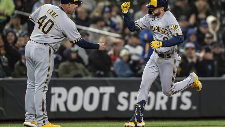 Apr 17, 2023; Seattle, Washington, USA; Milwaukee Brewers pinch hitter Brice Turang (0) is congratulated by third base coach Jason Lane while rounding the bases after hitting a solo home run seventh inning against the Seattle Mariners at T-Mobile Park. Mandatory Credit: Stephen Brashear-USA TODAY Sports