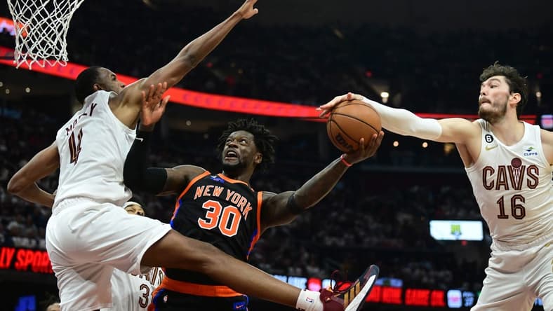 Apr 18, 2023; Cleveland, Ohio, USA; New York Knicks forward Julius Randle (30) drives to the basket between Cleveland Cavaliers forward Evan Mobley (4) and forward Cedi Osman (16) during the second quarter of game two of the 2023 NBA playoffs at Rocket Mortgage FieldHouse. Mandatory Credit: Ken Blaze-USA TODAY Sports