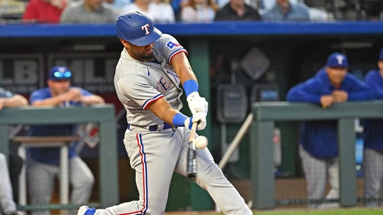 Apr 18, 2023; Kansas City, Missouri, USA; Texas Rangers shortstop Ezequiel Duran (20) hits an RBI single during the fourth inning against the Kansas City Royals at Kauffman Stadium. Mandatory Credit: Peter Aiken-USA TODAY Sports