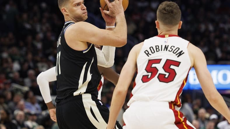 Apr 19, 2023; Milwaukee, Wisconsin, USA; Milwaukee Bucks center Brook Lopez (11) holds the ball away from Miami Heat guard Duncan Robinson (55) during the fourth quarter during game two of the 2023 NBA Playoffs at Fiserv Forum. Mandatory Credit: Jeff Hanisch-USA TODAY Sports