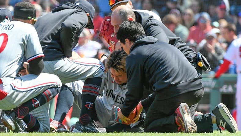 Apr 20, 2023; Boston, Massachusetts, USA; Minnesota Twins starting pitcher Kenta Maeda (18) is examined  after being struck by a ball hit by Boston Red Sox center fielder Jarren Duran (not pictured) at Fenway Park. Mandatory Credit: Eric Canha-USA TODAY Sports