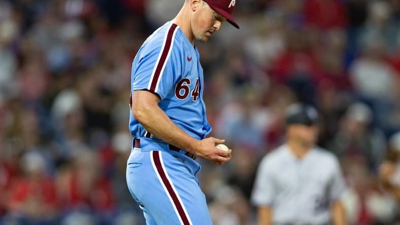 Apr 20, 2023; Philadelphia, Pennsylvania, USA; Philadelphia Phillies relief pitcher Andrew Bellatti (64) looks at the ball after walking in a run during the sixth inning against the Colorado Rockies at Citizens Bank Park. Mandatory Credit: Bill Streicher-USA TODAY Sports