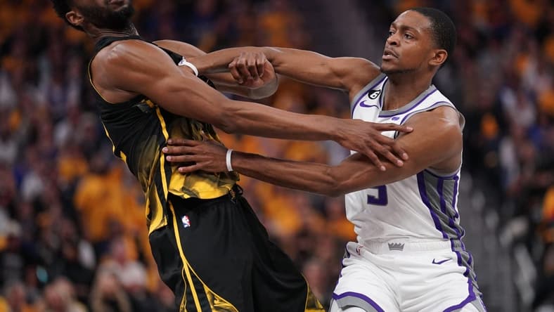Apr 20, 2023; San Francisco, California, USA; Golden State Warriors forward Andrew Wiggins (22) is fouled by Sacramento Kings guard De'Aaron Fox (5) in the second quarter during game three of the 2023 NBA playoffs at the Chase Center. Mandatory Credit: Cary Edmondson-USA TODAY Sports