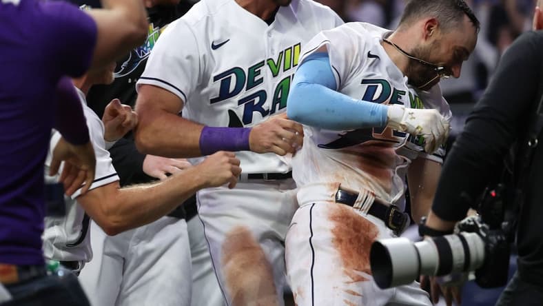 Apr 21, 2023; St. Petersburg, Florida, USA; Tampa Bay Rays second baseman Brandon Lowe (8) celebrates with teammates at home plate as he hits the game winning walk off 2-run home run against the Chicago White Sox at Tropicana Field. Mandatory Credit: Kim Klement-USA TODAY Sports