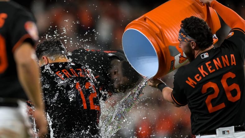 Apr 21, 2023; Baltimore, Maryland, USA;  Baltimore Orioles second baseman Adam Frazier (12)  gets water dumped on him by left fielder Ryan McKenna (26) after defeating against the Detroit Tigers   at Oriole Park at Camden Yards. Mandatory Credit: Tommy Gilligan-USA TODAY Sports