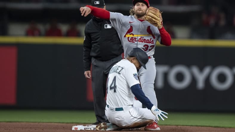 Apr 21, 2023; Seattle, Washington, USA; St. Louis Cardinals second baseman Brendan Donovan (33) turns a double play after forcing out Seattle Mariners centerfielder Julio Rodriguez (44) at second base during the third inning at T-Mobile Park. Mandatory Credit: Stephen Brashear-USA TODAY Sports