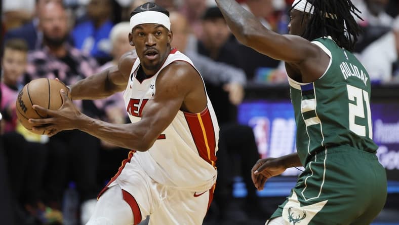 Apr 22, 2023; Miami, Florida, USA; Miami Heat forward Jimmy Butler (22) drives to the basket against Milwaukee Bucks guard Jrue Holiday (21) in the first quarter during game three of the 2023 NBA Playoffs at Kaseya Center. Mandatory Credit: Sam Navarro-USA TODAY Sports