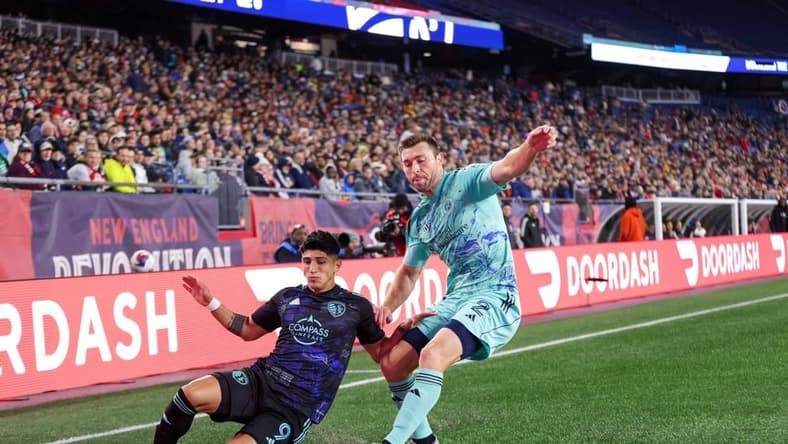 Apr 22, 2023; Foxborough, Massachusetts, USA; New England Revolution defender Dave Romney (2) defends Sporting Kansas City forward Alan Pulido (9) during the first half at Gillette Stadium. Mandatory Credit: Paul Rutherford-USA TODAY Sports