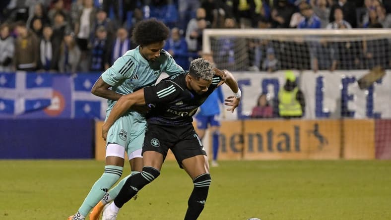 Apr 22, 2023; Montreal, Quebec, CAN; CF Montreal forward Ariel Lassiter (11) kicks the ball past New York Red Bulls defender Kyle Duncan (6) during the first half at Stade Saputo. Mandatory Credit: Eric Bolte-USA TODAY Sports