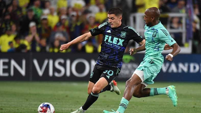 Apr 22, 2023; Nashville, Tennessee, USA; Los Angeles FC defender Sergi Palencia (30) handles the ball against Nashville SC midfielder Fafa Picault (7) during the first half at Geodis Park. Mandatory Credit: Christopher Hanewinckel-USA TODAY Sports