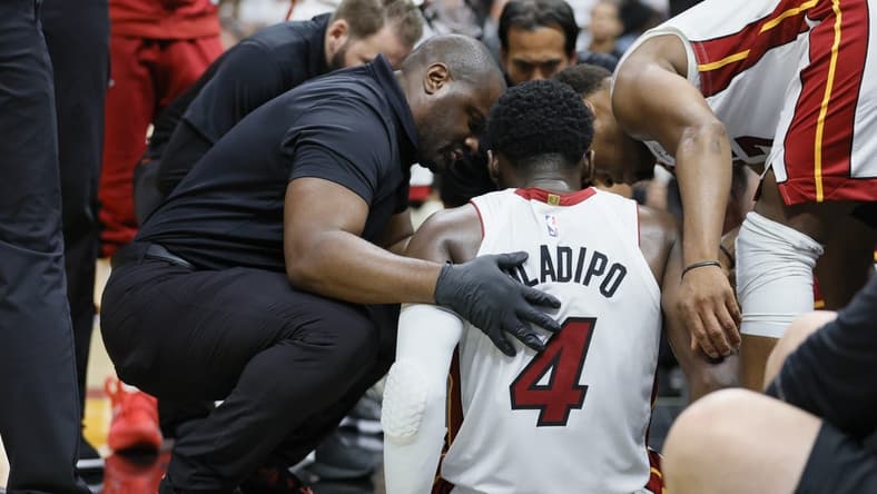 Apr 22, 2023; Miami, Florida, USA; Miami Heat guard Victor Oladipo (4) is checked on after an injury in the fourth quarter against the Milwaukee Bucks during game three of the 2023 NBA Playoffs at Kaseya Center. Mandatory Credit: Sam Navarro-USA TODAY Sports