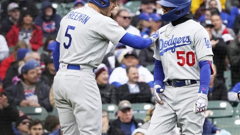 Apr 23, 2023; Chicago, Illinois, USA; Los Angeles Dodgers right fielder Mookie Betts (50) is greeted by first baseman Freddie Freeman (5) after hitting a two-run homer against the Chicago Cubs during the third inning at Wrigley Field. Mandatory Credit: David Banks-USA TODAY Sports