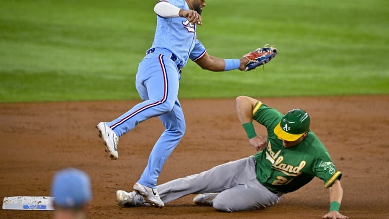 Apr 23, 2023; Arlington, Texas, USA; Oakland Athletics right fielder Conner Capel (21) slides under the tag of Texas Rangers shortstop Ezequiel Duran (20) during the second inning at Globe Life Field. Mandatory Credit: Jerome Miron-USA TODAY Sports