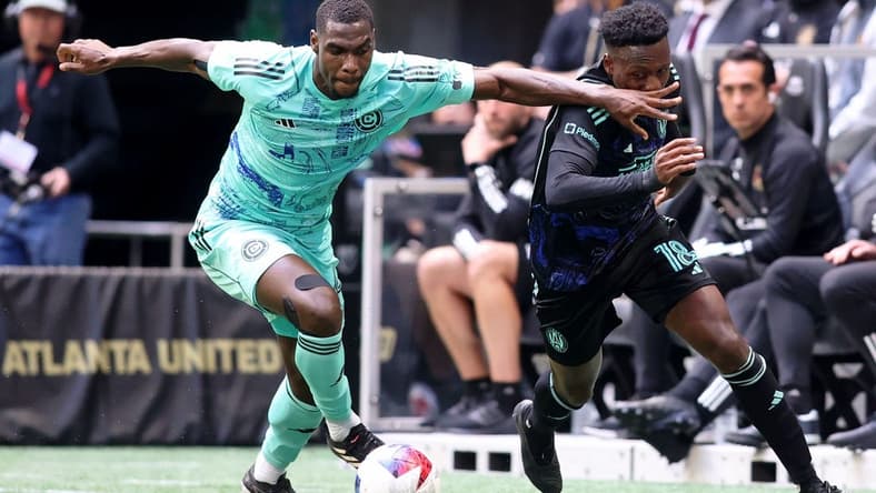 Apr 23, 2023; Atlanta, Georgia, USA; Chicago Fire defender Carlos Teran (4) battles for the ball against Atlanta United midfielder Derrick Etienne (18) during the first half at Mercedes-Benz Stadium. Mandatory Credit: Brett Davis-USA TODAY Sports