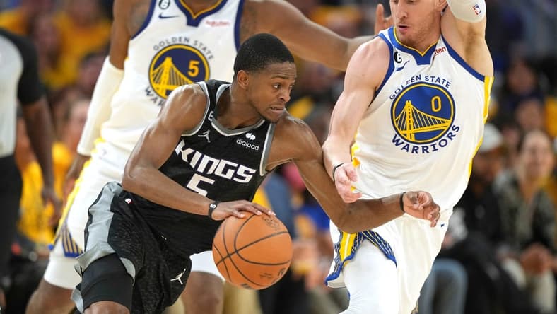 Apr 23, 2023; San Francisco, California, USA; Sacramento Kings guard Malik Monk (0) dribbles against Golden State Warriors guard Donte DiVincenzo (0) during the third quarter of game four of the 2023 NBA playoffs at Chase Center. Mandatory Credit: Darren Yamashita-USA TODAY Sports